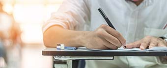 School exam student's taking educational admission test in class, thinking hard, writing answer in university classroom, education and world literacy day concept